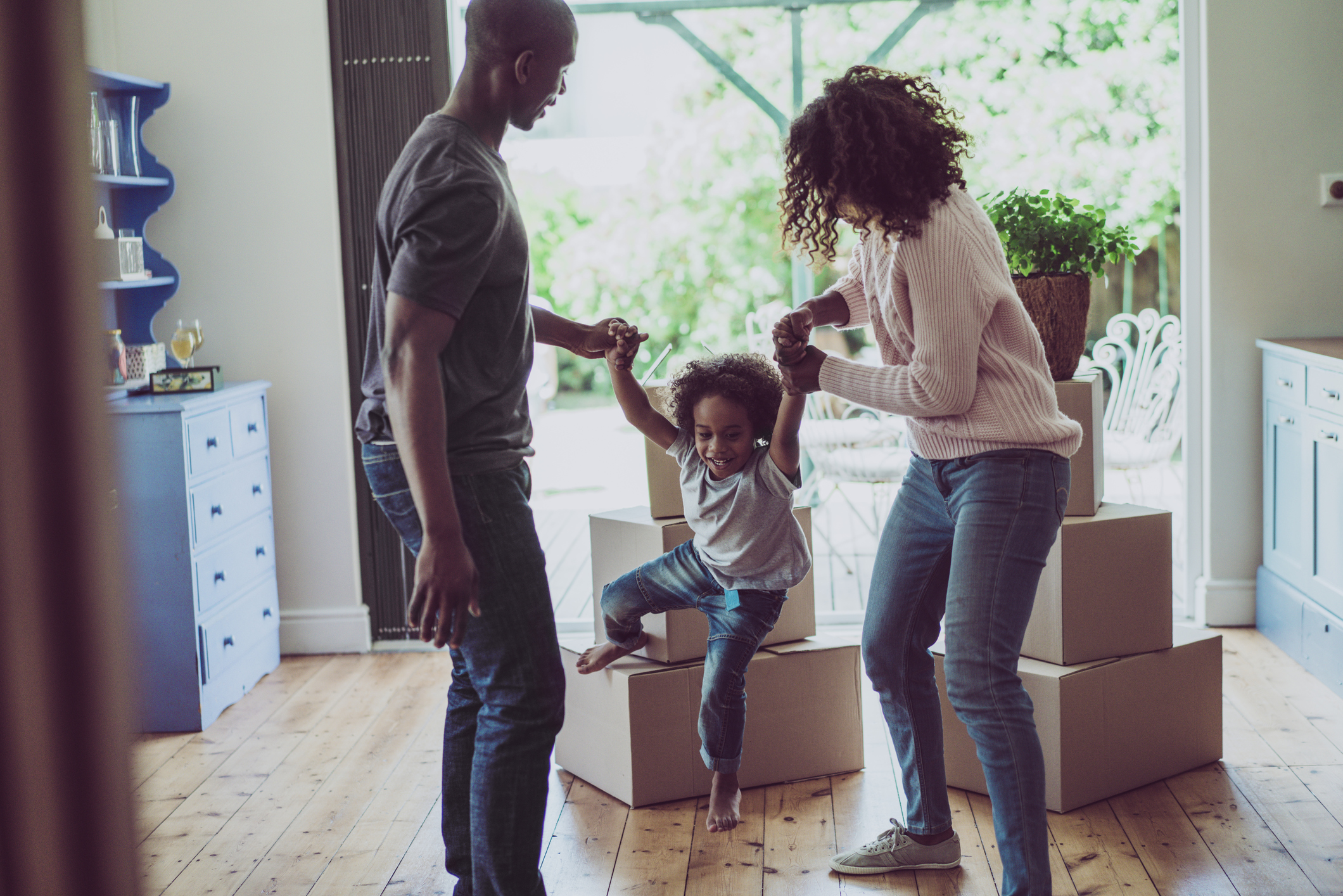 Couple having fun with a small child and moving boxes